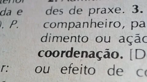 A man marks the word coordination definition in portuguese  on a printed page wi Stock Footage 297276929