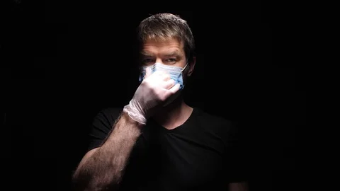 A man in a Mask and Gloves is Preparing to Fight the Pandemic. Shows a Fig for C Stock Footage 127865031