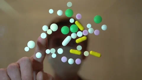 The man in the mask on the blurred background gathers in groups of colored pills Stock Footage 130189902