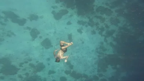 Man in mask dives deep after releasing a bubble floats through ring of bubbles Stock Footage 231446830