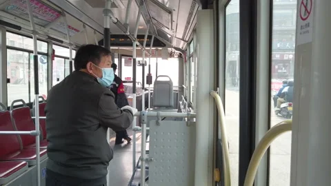 Man with mask getting off empty bus in coronavirus pandemic, Beijing, China Stock Footage 149299114