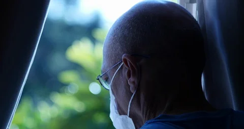 Man with mask looking out the window, Senior Man, covid Isolation Concept Stock Footage 127601856