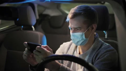 Man in mask or a driver playing online game exciting mobile application winning Stock Footage 143858244
