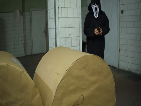 A man in a mask rolls out a large roll of paper in old Newspaper factory Stock Footage 79166438