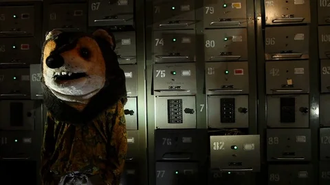 A man with a mask in the shape of a bear’s head standing against the Stock Footage 125005659