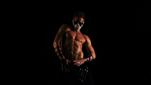 Man in a mask of a skull and glasses dance on black background Stock Footage