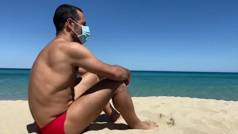 Man with mask sunbathing on the beach Stock Footage 132667959