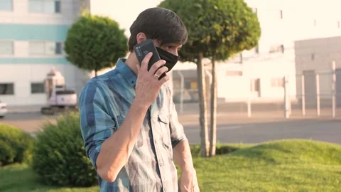 A man in a mask talking on a smartphone  Stock Footage 137608723