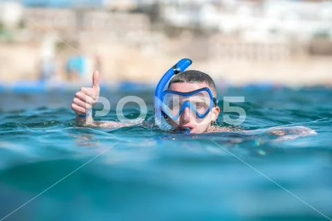 The man with mask thumb up in the sea Stock Photos