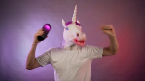 The man in the mask of a unicorn dancing with a column in hand Stock Footage 128998279