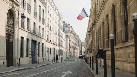 Man with mask walking deserted Paris street during coronavirus quarantine 4K Stock Footage 128385599