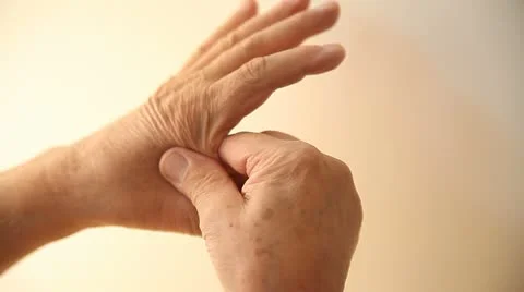 Man massages area on hand Stock Footage 12169275