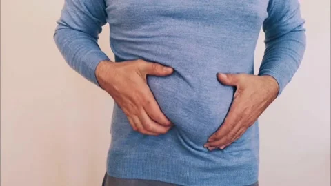 Man massaging and slapping his beer belly Stock Footage 237534812