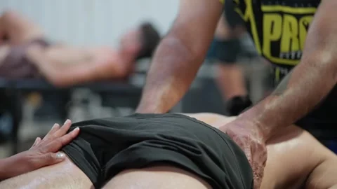 Man massaging another man's back after a CrossFit competition 스톡 동영상 308215756