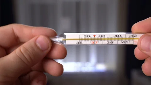 Man measure the temperature with a mercury thermometer Stock Footage 128691904