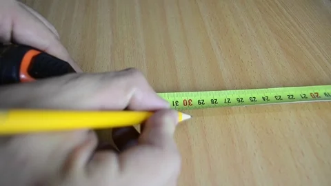 A man measures a desk Stock Footage 115205355