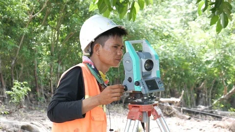A man measures land topography using electronic theodolite Stock Footage 124270812