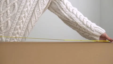 A man measures the length of a cardboard sheet Stock Footage 142931801