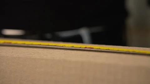 A man measures the length of a large stack of cardboard Stock Footage 142623798