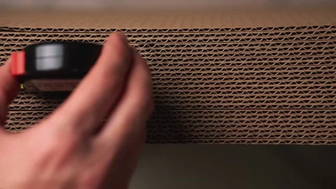 A man measures the length of a stack of cardboard Stock Footage 142623551