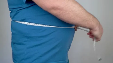 Man measures the size of the abdomen with a centimeter measuring tape Stock Footage 151378426