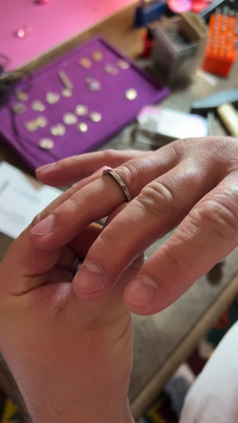 Man measures size of his ring finger with finger meter at jewelry workshop Stock Footage 310902521