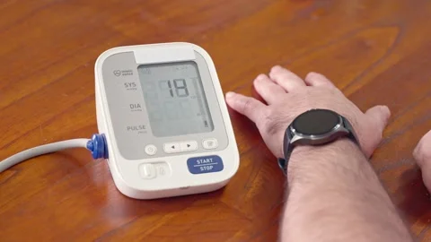 Man measuring blood pressure with an automatic tonometer at home Stock Footage 328128414