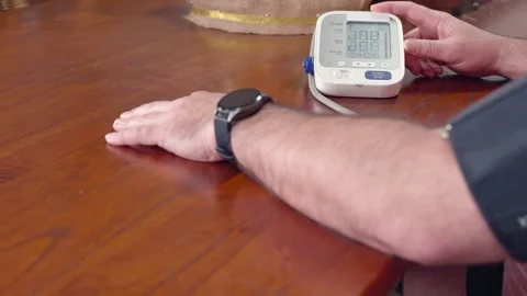 Man measuring his blood pressure at home Stock Footage 328537792