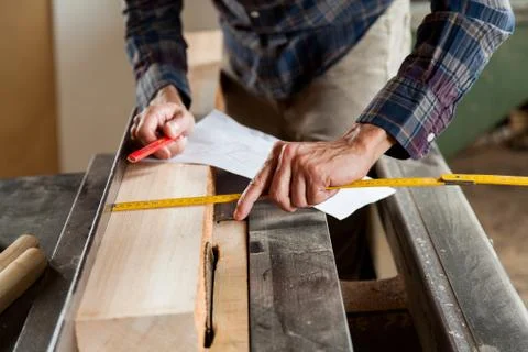 Man measuring a plank Фото