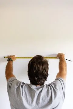 Man measuring wall for home improvement project Stock Photos