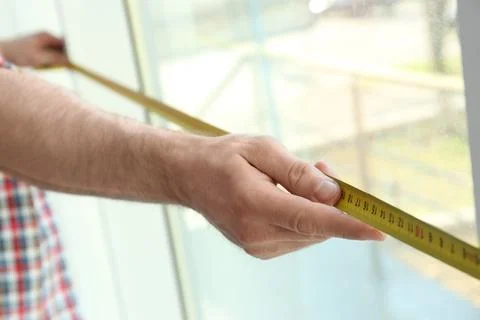 Man measuring window, closeup view. Construction tool 스톡 사진