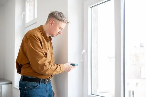 Man Measuring Window Opening Foto stock
