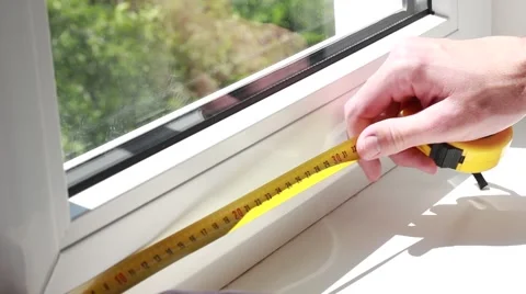Man measuring a window with yellow tape-line Видео 64621495