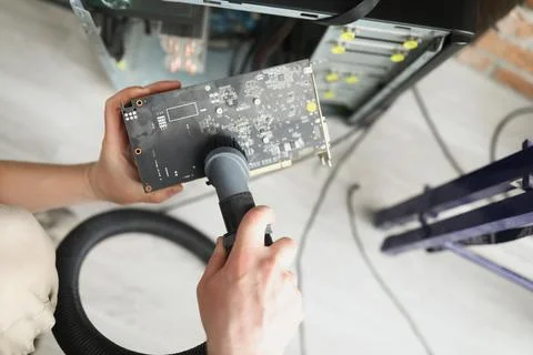 Man mechanic clean computer processor detail with vacuum cleaner nozzle Stock Photos