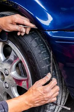 Man mechanic installing the front bumper with his hands of a blue car exterio Stock Photos