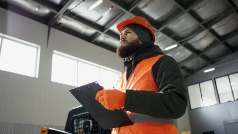 A man mechanic uses notes in an auto repair garage. Mechanics overhauling an Stock Footage 115700969