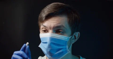 A man in a medical mask eats a pill from the virus Stock Footage 127635830