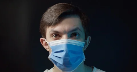 A man in a medical mask eats a pill from the virus Stock Footage 127635986