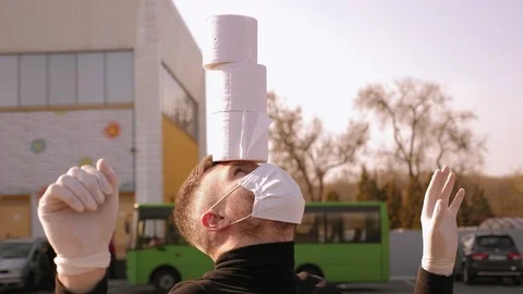 A man in medical mask having fun in the parking with toilet paper. COVID-19. Stock Footage 128317261