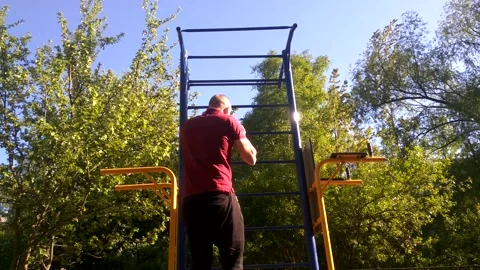A man in a medical mask pulls himself up on a horizontal bar Stock-Footage 131548548
