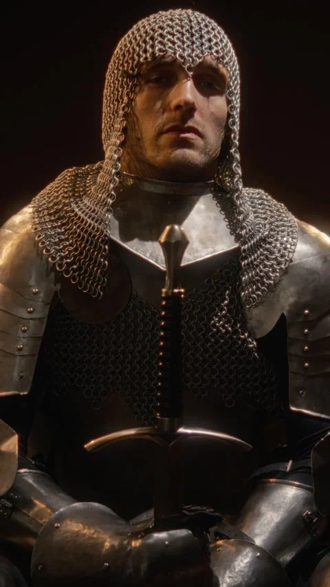 Man in Medieval Armor Holding Sword with Head Bowed in Prayer Stock Footage 345522031