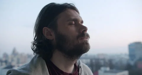 Man meditates in urban background, eyes closed, mindfulness mental practices Video stock 238772353