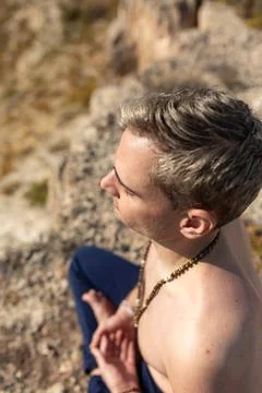 A man meditates, while using the Padmasana pose, during a yoga session in the Stock Photos