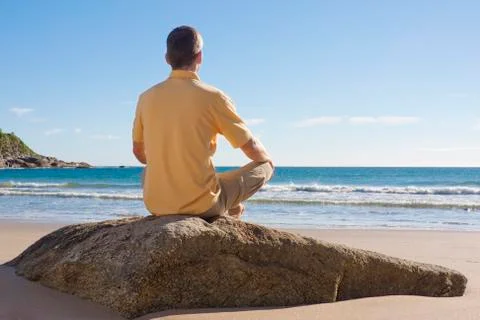 Man meditating on a beach Фото