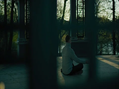 Man meditating, camera slides outside window 스톡 동영상 77543462