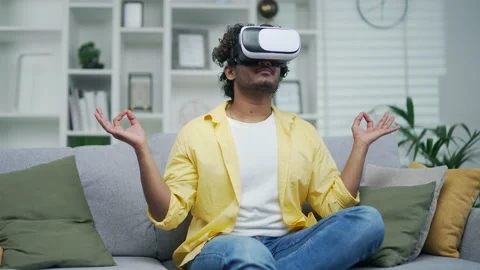 Man meditating at home with virtual reality vr headsets glasses doing yoga  Stock Footage 235504972