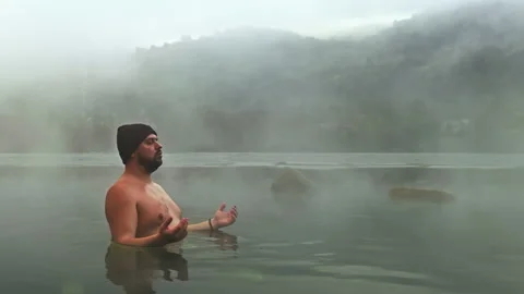 Man meditating in hot spring with misty background Stock Footage 280257983