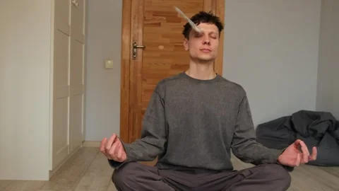 Man meditating in a lotus position while practicing financial flow meditation as Stock Footage 303892163