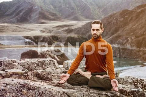 Man meditating in the mountains Stock Photos