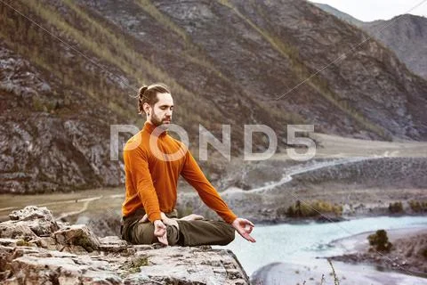 Man meditating in the mountains Stock Photos